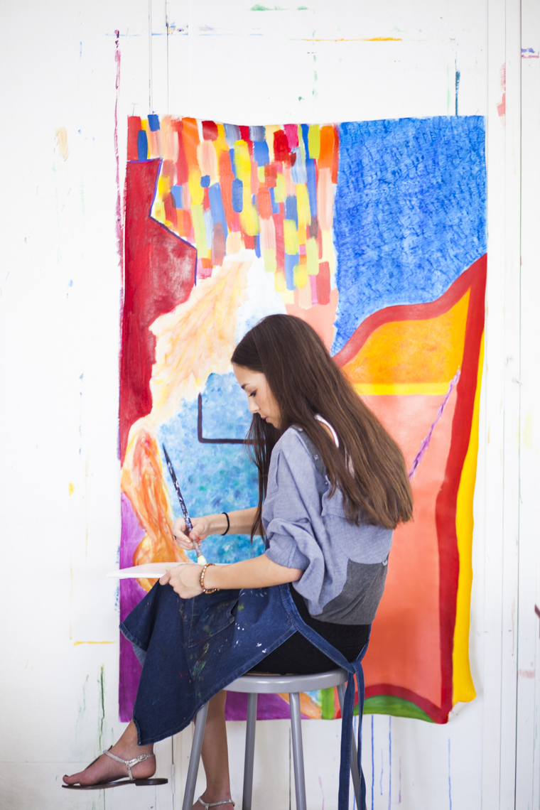 A female student works on a painting during an art class at a private high school in a photo by Ryan Donnell