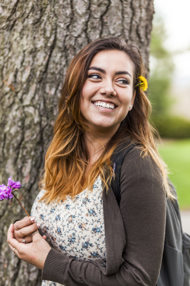 A portrait of a smiling college student on campus in a photo by Ryan Donnell