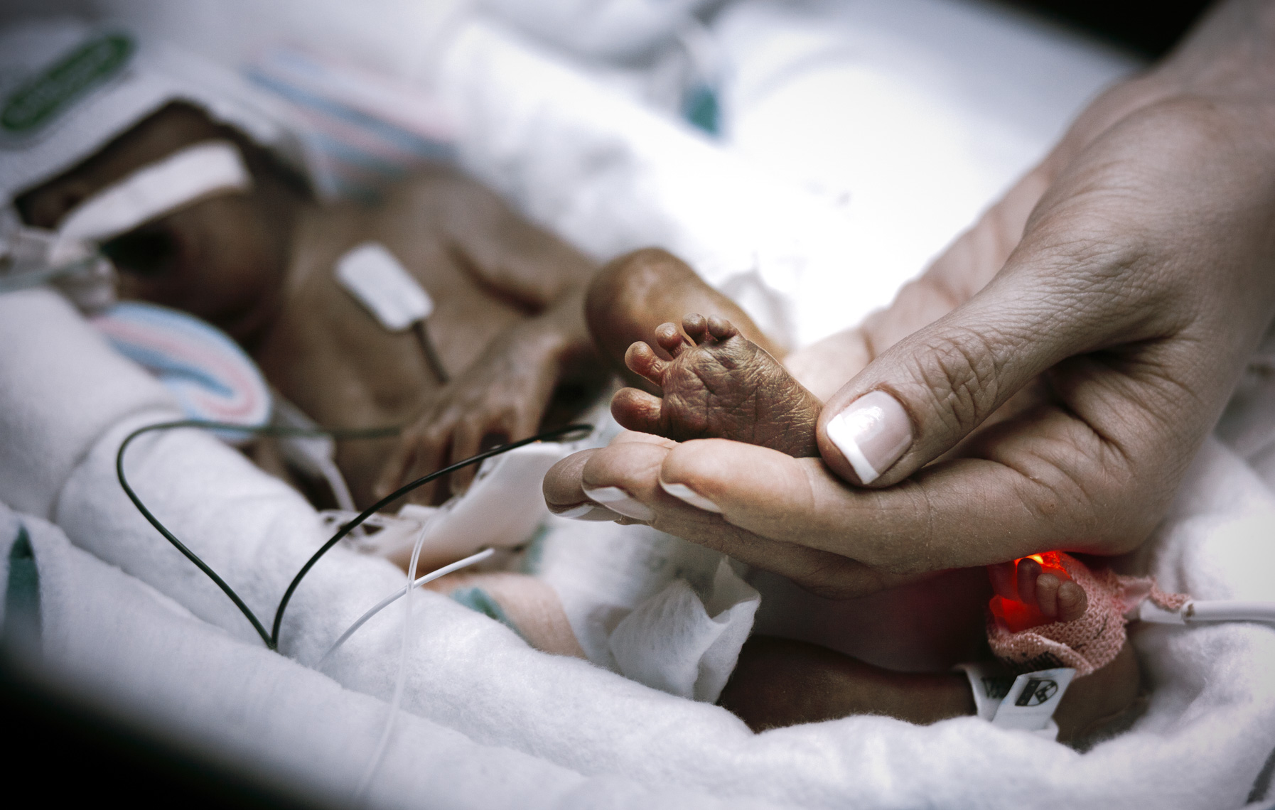 A nurse touches the foot of a premature baby in the Neonatal Intensive Care Unit of a hospital in Philadelphia.