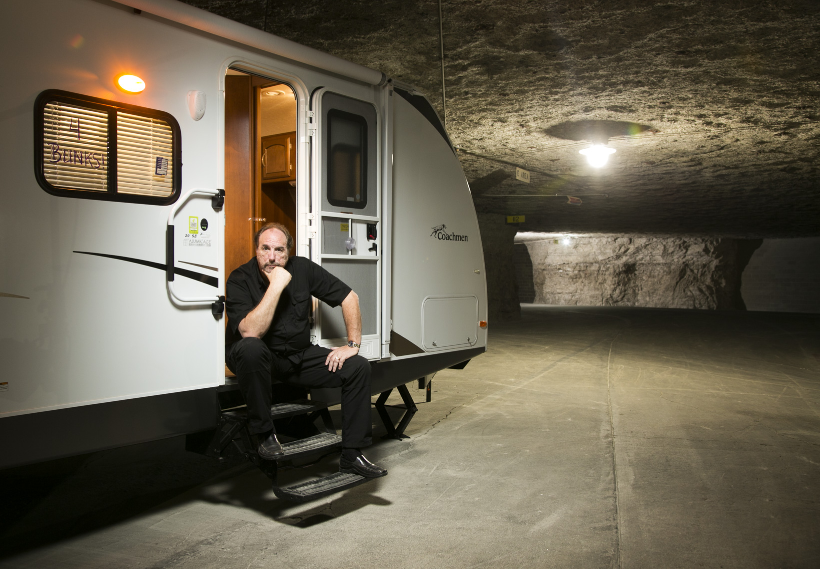 A portrait of a man sitting on an RV in a bomb shelter by Washington DC photographer Ryan Donnell