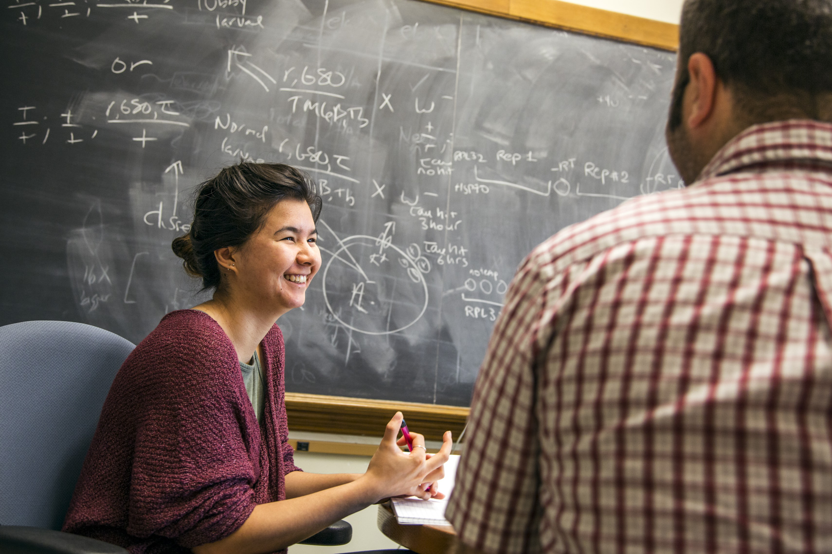 A college student laughs with her professor during a study session in a photo by Ryan Donnell