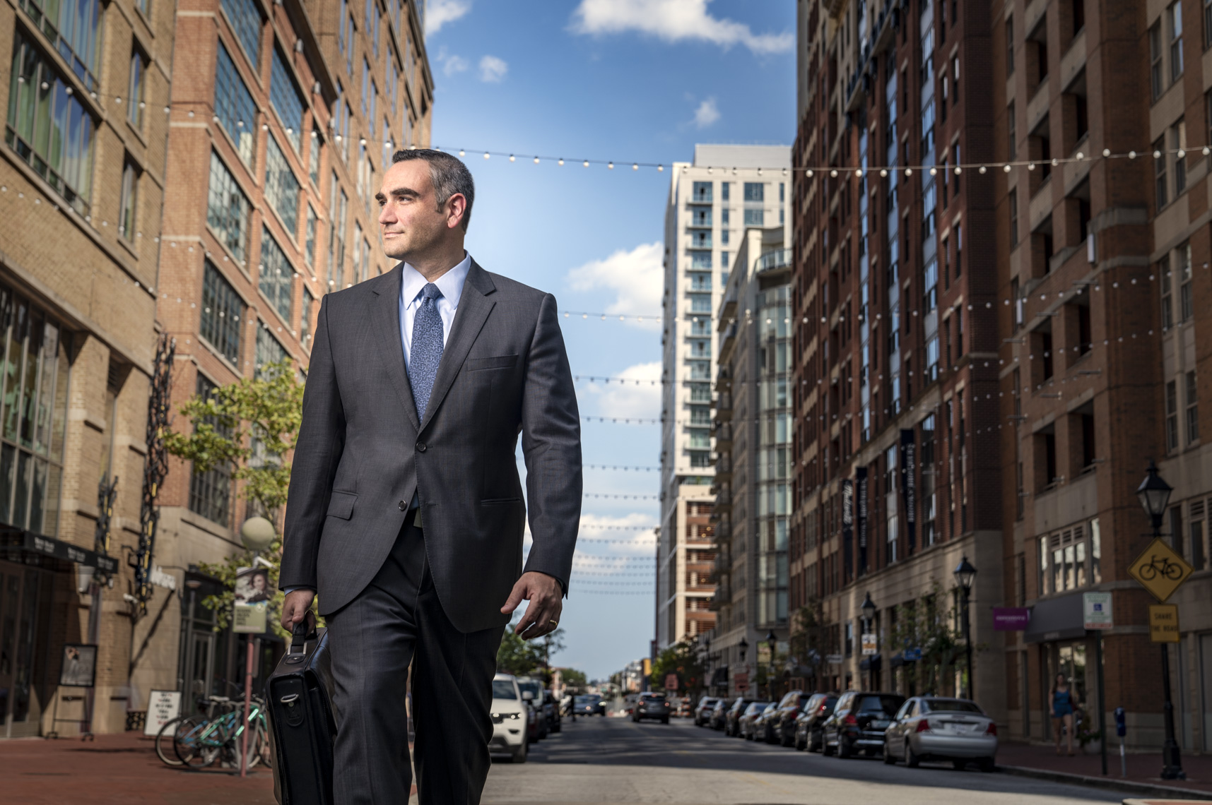 Portrait of a business man walking down a street with briefcase  by Washington DC photographer Ryan Donnell