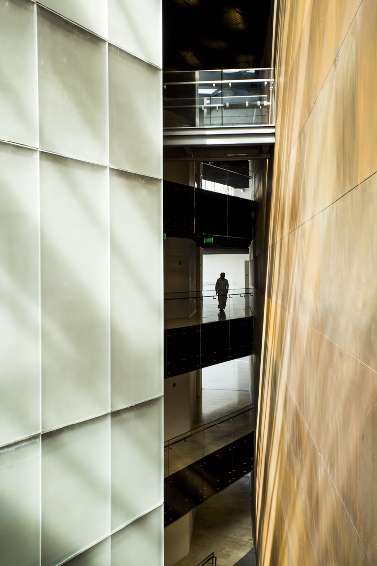 A campus beauty and architectural photo of students walking on a modern university building in a photo by Ryan Donnell